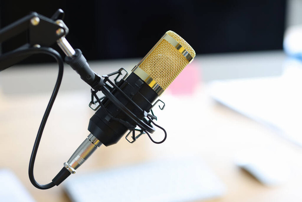 Золотий мікрофон стоїть на столі в студії звукозапису крупним планом
 - Фото, зображення
