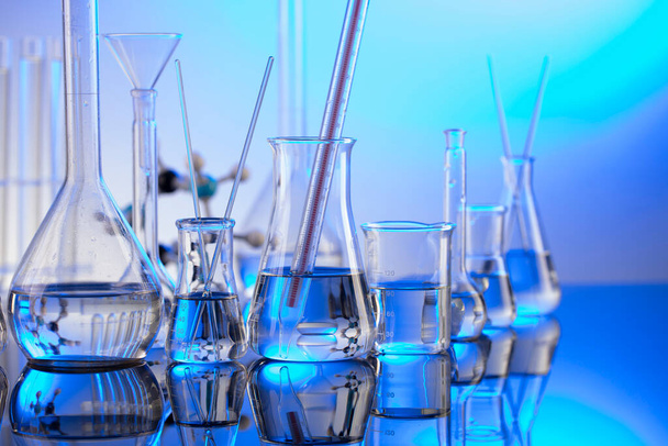 Investigações laboratoriais. Tubos e copos de vidro sobre fundo azul. - Foto, Imagem