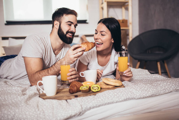 Romantic happy couple having breakfast in bed - Photo, Image