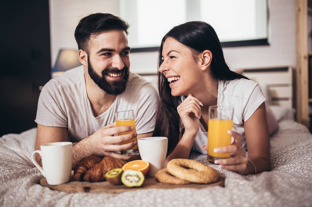 Романтическая счастливая пара завтракает в постели - Фото, изображение