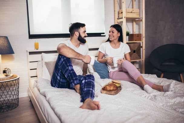 Romántica pareja feliz desayunando en la cama - Foto, imagen