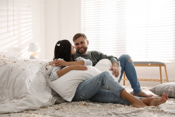 Happy young couple resting after fun pillow fight in bedroom - Photo, Image