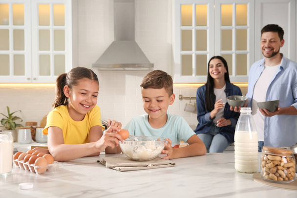 Happy family cooking together at table in kitchen. Adoption concept - Valokuva, kuva