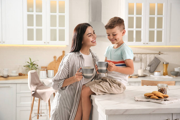 Happy mother and son having breakfast together in kitchen. Adoption concept - Fotografie, Obrázek