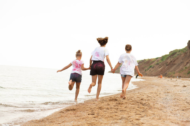 children run along the beach, near the sea, beautiful sunset, children's feet - Foto, Bild