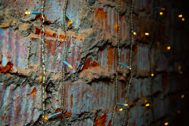 Eelectric garland on brick wall background - Фото, изображение