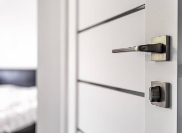 Close-up of metal door handle of an open door to a room. - Photo, Image