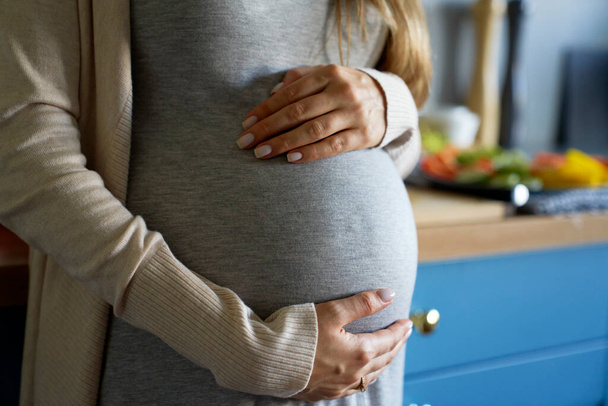 Primer plano de la barriga embarazada en casa  - Foto, imagen
