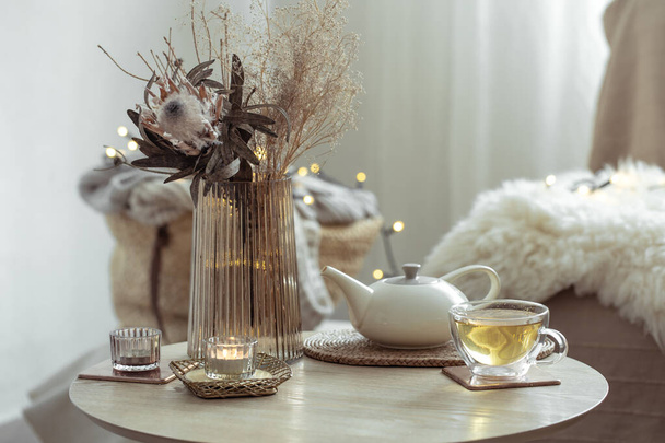 A cozy composition with tea and decorative details against a blurred background of the interior of the room. - Photo, Image
