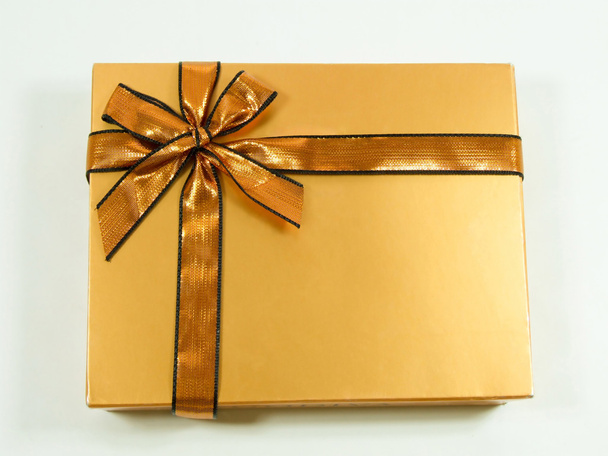 Gold gift with shinny ribbon and bow - Фото, зображення