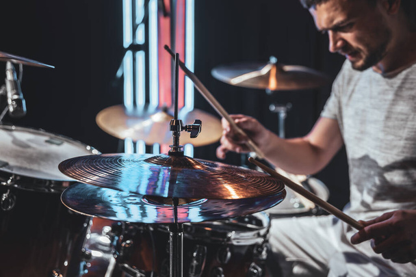 The drummer plays with beautiful lighting on a blurred background. - Photo, Image