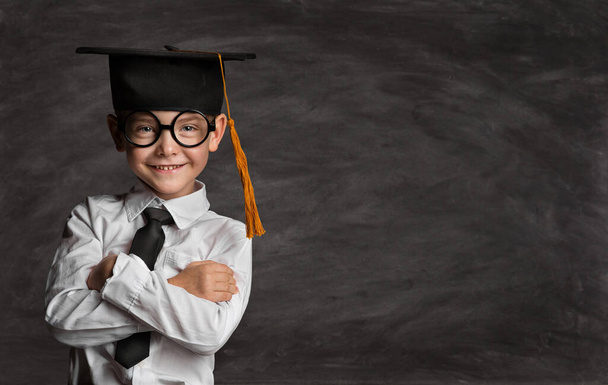 Happy Preschooler Boy in Eyeglasses and Graduation Hat over Blackboard with Copy Space. Happy Little Kid like Student in Smart Casual White Shirt Black Tie. Clever Child in Master Cap - Фото, зображення
