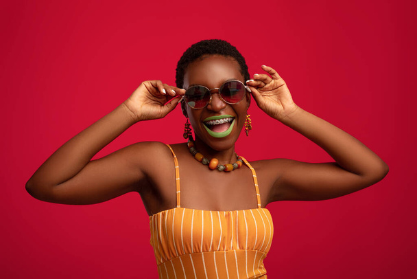 Pretty african american young woman trying new sunglasses - Foto, Imagem
