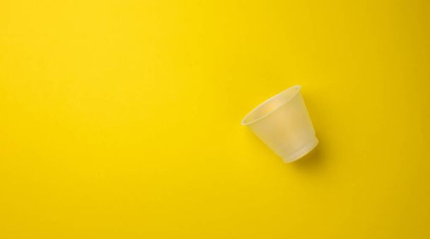 tasse en plastique vide sur fond jaune, vue de dessus - Photo, image