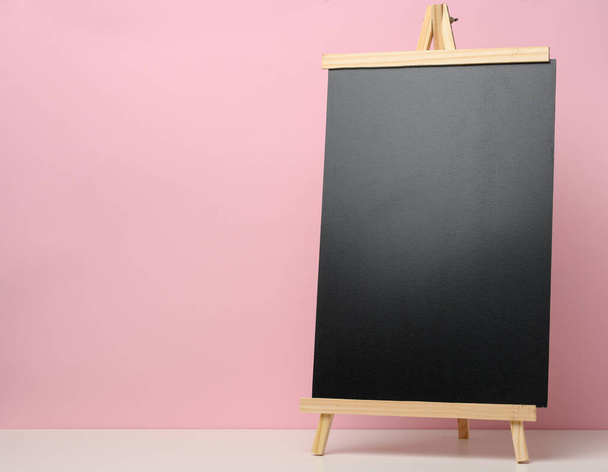 empty black slate board on white table, pink background. Place for the inscription of the announcement - Фото, зображення