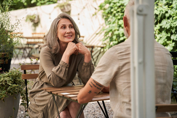 Woman looking with tenderness at her husband while sitting at the cafe - Foto, Imagen