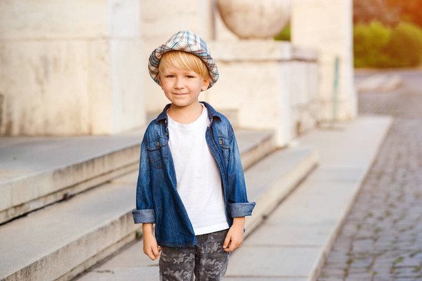 Happy child walking the city street. Cute boy wearing stylish summer outfit. Child with positive emotions. Kids summer fashion. Happy and healthy childhood. - Φωτογραφία, εικόνα