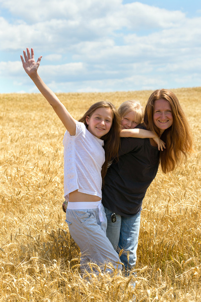 Mother with daughters on wheat field - Photo, Image
