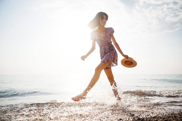 Portrait of young woman walking on the beach on sunrise - 写真・画像
