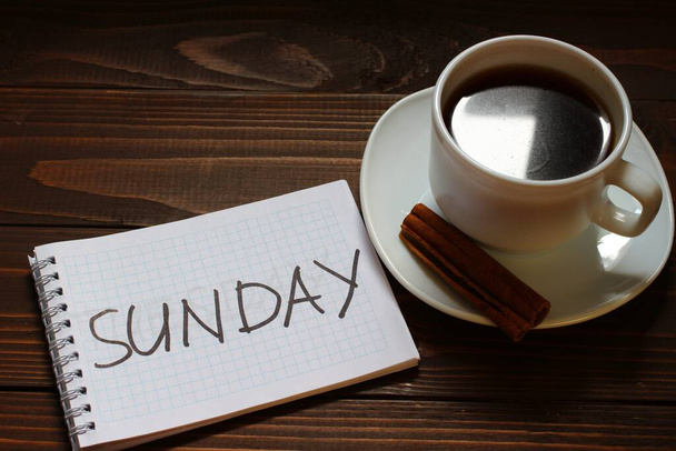 コーヒーカップの近くのノートに日曜日の碑文と単語 - 写真・画像