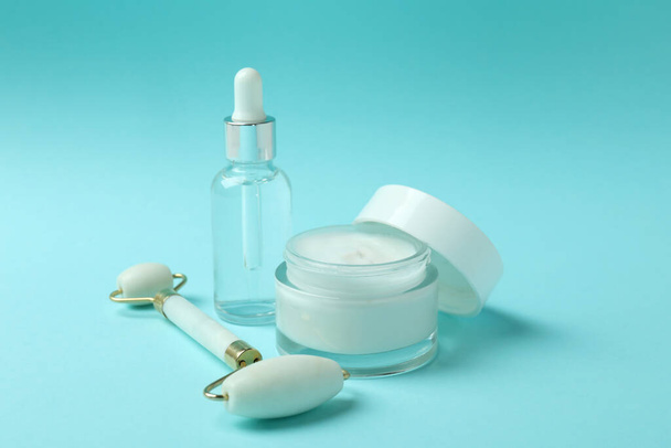 Skin care concept with face roller on blue background - Foto, Imagem
