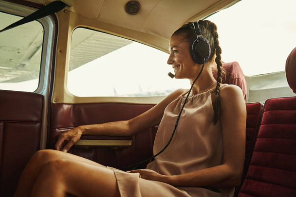 Positive delighted brunette woman enjoying the flight - Φωτογραφία, εικόνα