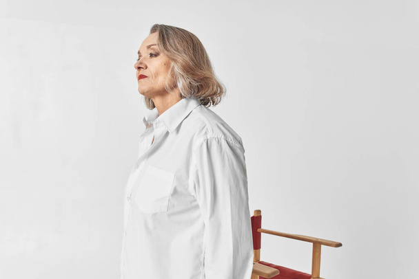 starší žena v bílé košili sedí na židli close-up životní styl - Fotografie, Obrázek