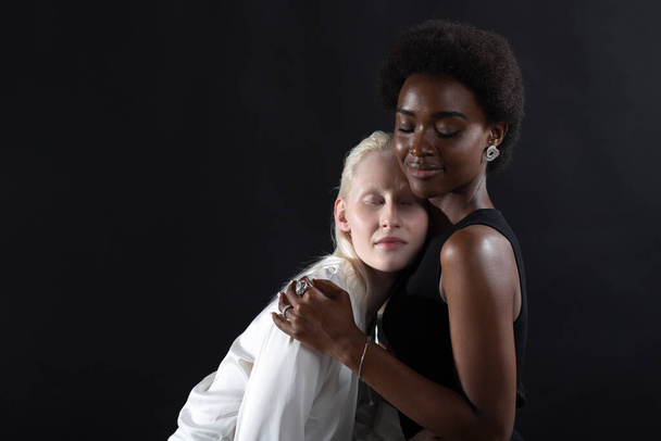 Caucasian and african american young woman isolated on black background. - Foto, Imagem