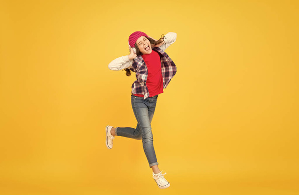 Let the music take you away. Energetic girl move to music. Little kid enjoy singing yellow background. Headphones technology. Modern life. Happy dance. Play the moment - Photo, image