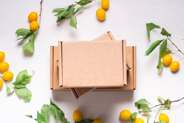 Brown Cardboard Carton box with fresh green leaves - Foto, imagen