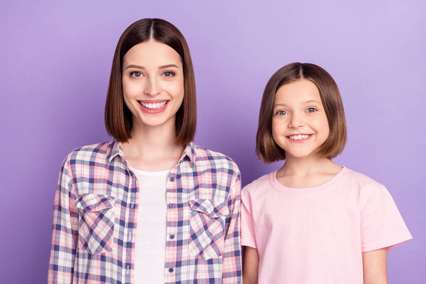 Portrait of two attractive cheerful girls best friends isolated over purple violet color background - Foto, Bild