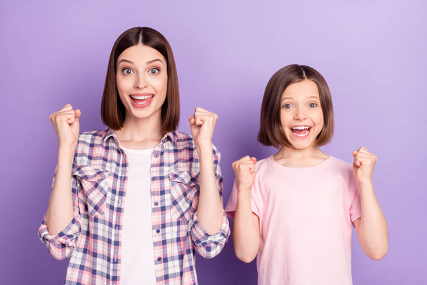 Portrait of two attractive cheerful lucky girls rejoicing having fun isolated over purple violet color background - Foto, Imagen