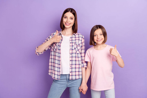 Portrait of two attractive cheerful glad girls friends showing thumbup advert isolated over purple violet color background - Valokuva, kuva