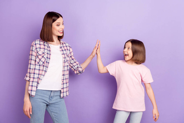 Portrait of two attractive cheerful girls best friends clapping palms isolated over purple violet color background - Foto, Bild