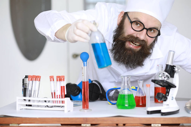 Químico loco. Un científico loco lleva a cabo experimentos en laboratorio científico. Realiza investigaciones utilizando un microscopio. - Foto, Imagen