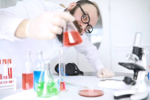 Chimico pazzo. Uno scienziato pazzo conduce esperimenti in laboratorio scientifico. Esegue la ricerca al microscopio. - Foto, immagini