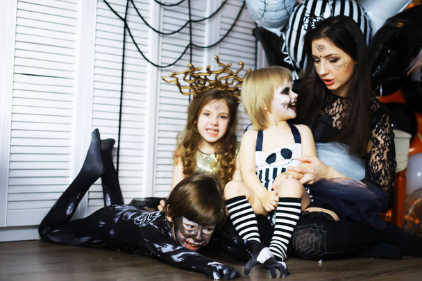 ハロウィーンのお祝いに衣装や化粧の子供たちと幸せな家族 - 写真・画像