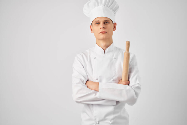 chef-kok met een witte dop op zijn hoofd keukengerei koken - Foto, afbeelding