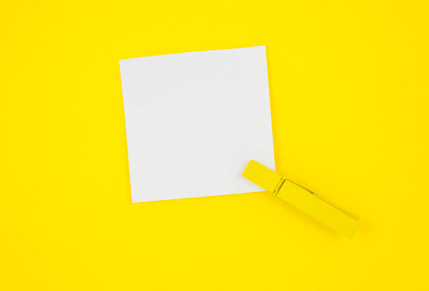 Blank white To Do List Sticker with yellow wooden clothespin. Close up of reminder note paper on the yellow background. Copy space. Minimalism, original and creative photo. - Φωτογραφία, εικόνα