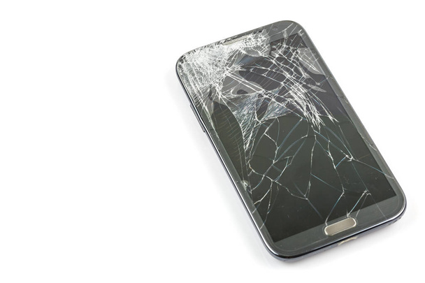 Smartphone cadere a terra e danni allo schermo rotto isolato su sfondo bianco - Foto, immagini