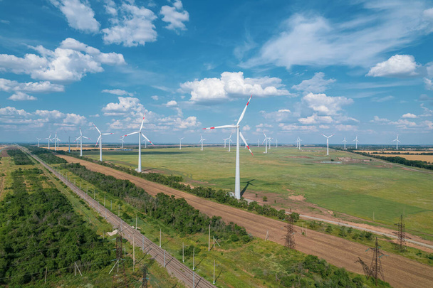Вид с воздуха на ветроэнергетическую турбину является популярным устойчивым, возобновляемым источником энергии на красивом облачном небе. Ветроэнергетические турбины, генерирующие чистую возобновляемую энергию для устойчивого развития. - Фото, изображение