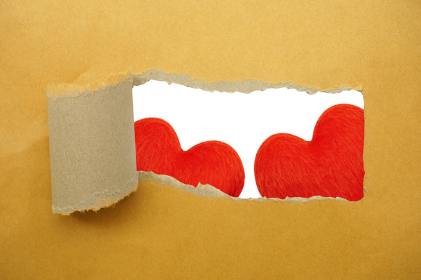 Red heart under torn paper strip - Фото, изображение