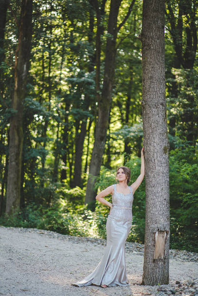 A Caucasian female from Bosnia and Herzegovina in an elegant dress with trees in the background - Photo, Image
