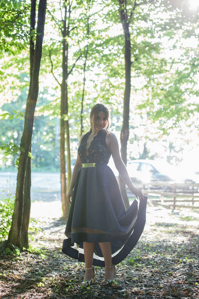 A Caucasian female from Bosnia and Herzegovina in an elegant blue dress with trees in the background - Foto, Bild