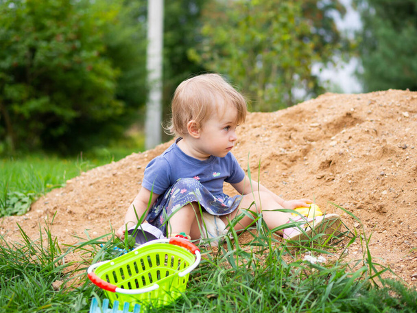 mooi een jaar oud meisje spelen in de zandbak - Foto, afbeelding