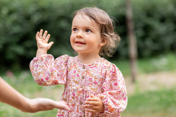 happy smiling baby girl giving hand to adult - Valokuva, kuva