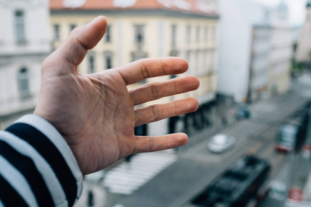 A man hand over a street background - Фото, изображение