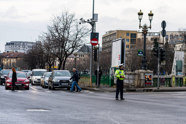 Polizeichef der rumänischen Verkehrspolizei (Politia Rutiera) lenkt den Verkehr während der Hauptverkehrszeit in der Innenstadt von Bukarest, Rumänien, 2021 - Foto, Bild