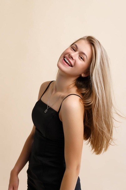Portrait of a smiling young woman on a beige background - Foto, Bild