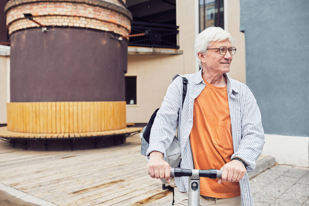 Mature Man Riding Scooter in City - Photo, Image